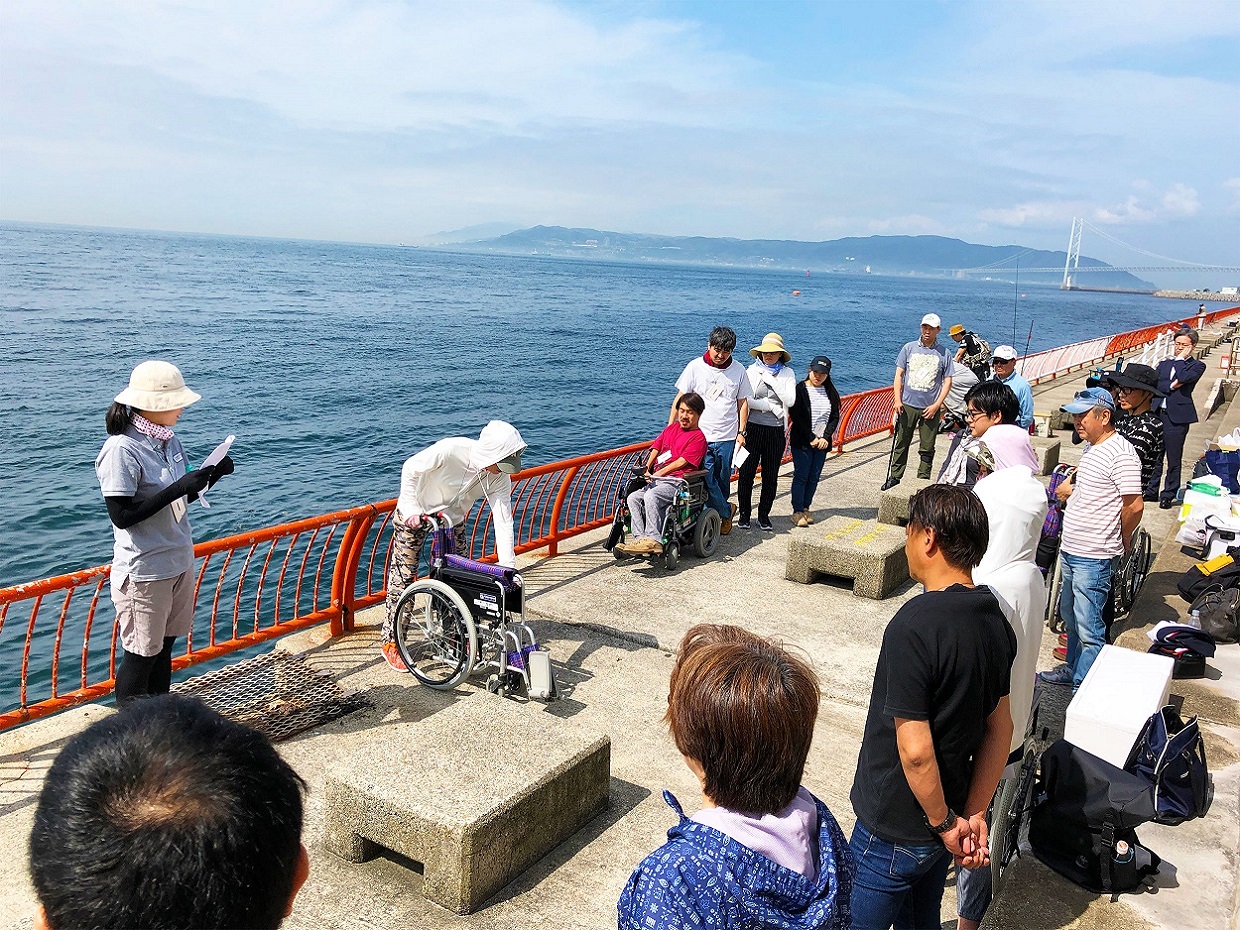 海をバックに車いすの操作方法を参加者全員で学習中