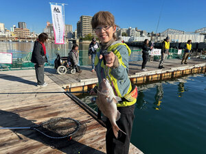 桟橋の上で魚を持った女性